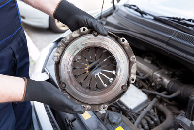 Midsection of man repairing car engine