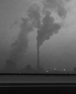 Smoke emitting from chimney against sky