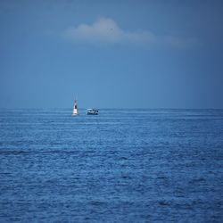 Boat sailing in sea against blue sky