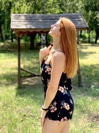 Side view of young woman standing on field