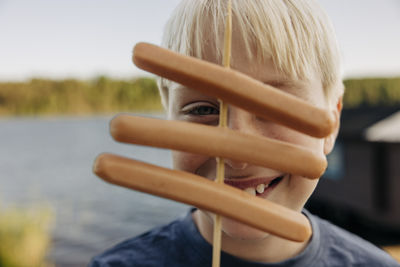 Portrait of blond boy with sausages at summer camp