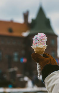 Close-up of hand holding ice cream against blurred background