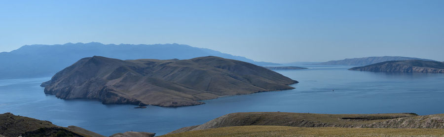 Panoramic view of sea and mountains against clear sky