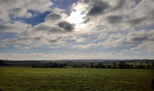 Scenic view of field against cloudy sky