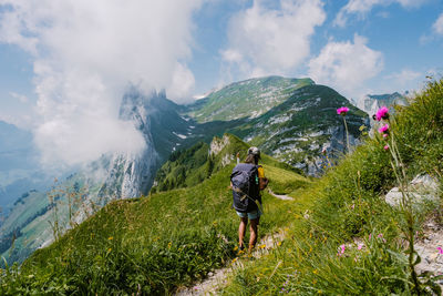 Rear view of people walking on trail against sky