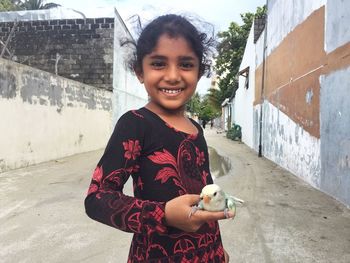 Portrait of smiling girl holding bird