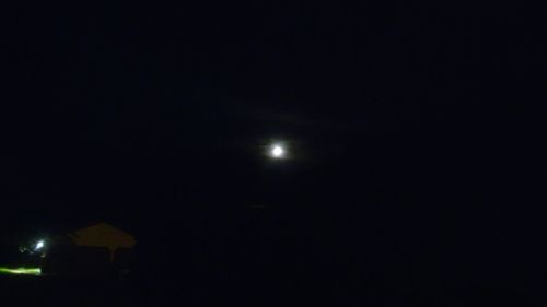 Low angle view of illuminated moon against sky at night