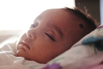 Close-up portrait of cute baby sleeping on bed