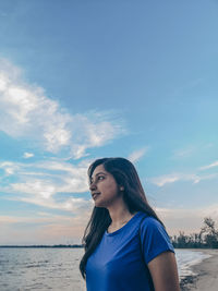 Portrait of woman looking at sea against sky