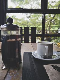 Coffee cup on table by window at home