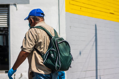 Rear view of man standing against wall
