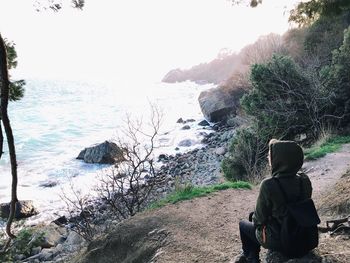 Man standing on rocks by sea