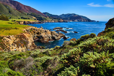 Scenic view of sea and mountains against sky