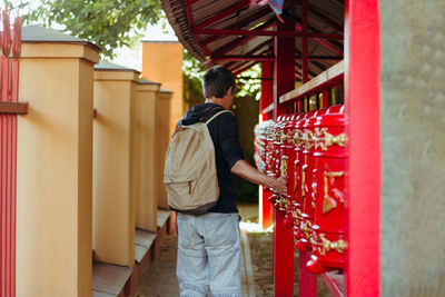 Rear view of man standing outside temple