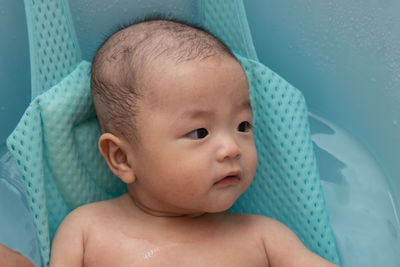 Cute baby girl lying in container