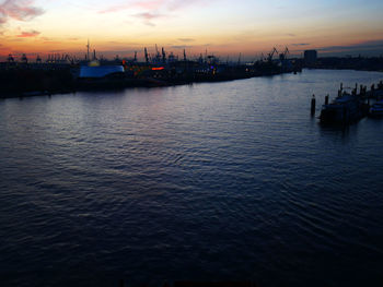 Silhouette boats in sea against sky at sunset