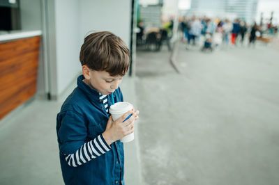 Boy drinking coffee outdoors
