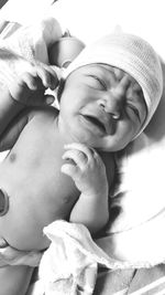 Close-up of baby girl lying on bed