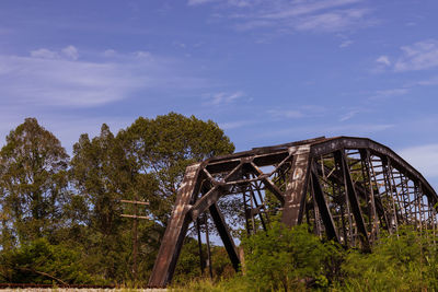 Low angle view of abandoned metallic structure against sky