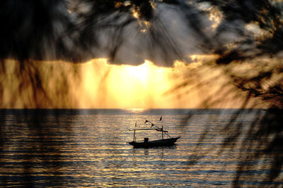 Silhouette boat in sea against sky during sunset