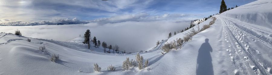 Panoramic view of snow covered mountains against sky