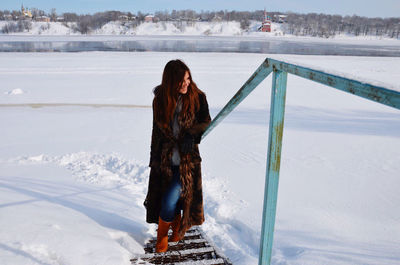 Woman standing on snow covered landscape during winter