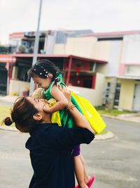 Rear view of mother and son standing on outdoors