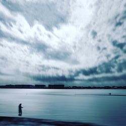 Silhouette man standing on beach against sky