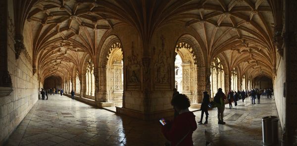 People walking in corridor of historic building