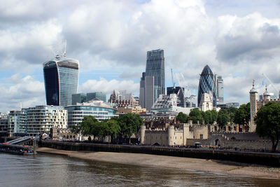 Buildings in city against cloudy sky