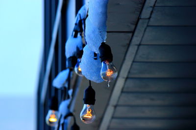 Low angle view of illuminated light bulbs on house