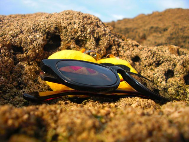 CLOSE-UP OF SUNGLASSES ON ROCK