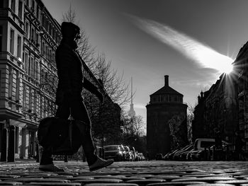 Man standing in city against sky