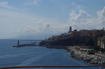 Panoramic view of sea and buildings against sky
