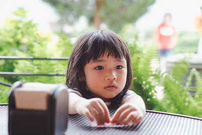 Portrait of cute boy with mobile phone outdoors