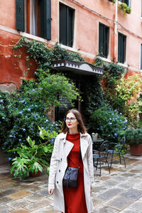 Young tourist in dress and coat on the streets of venice