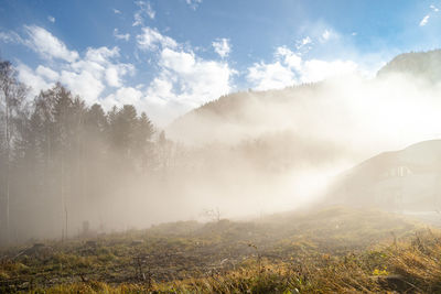 Scenic view of foggy weather against sky
