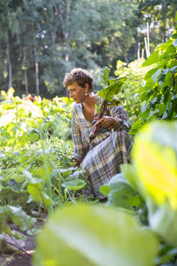 Side view of woman sitting on field