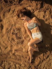 Full length of young woman with horse on sand at beach