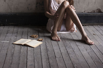 Low section of woman sitting on wooden floor