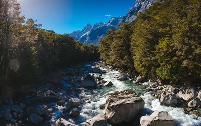 River flowing amidst rocks against sky