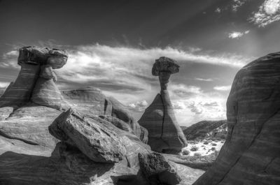 Statue of rock formations against cloudy sky
