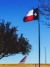 Low angle view of flags against blue sky