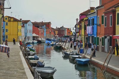 Boats are moored in a canal among colorful houses