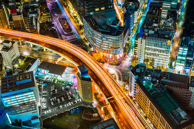 Aerial view of highway amidst buildings in city at night