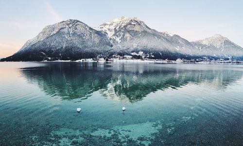 Scenic view of lake and snowcapped mountains against sky