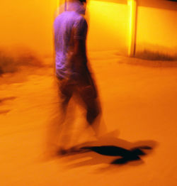 Low section of man walking on street at night