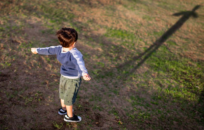 Rear view of boy standing on field