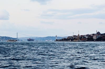 Boats in sea with buildings in background