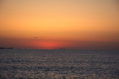 Scenic view of sea against orange sky